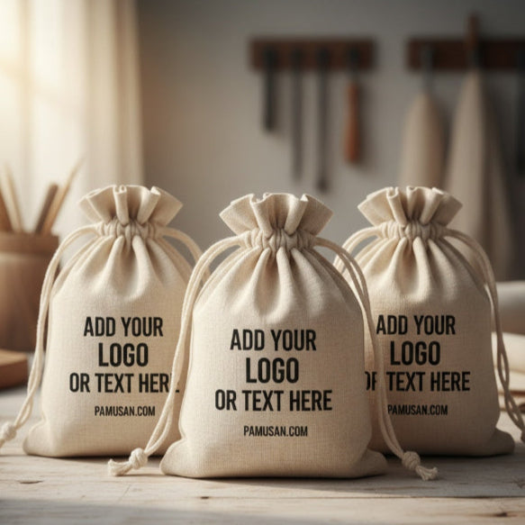 Three beige drawstring bags with text on a wooden surface