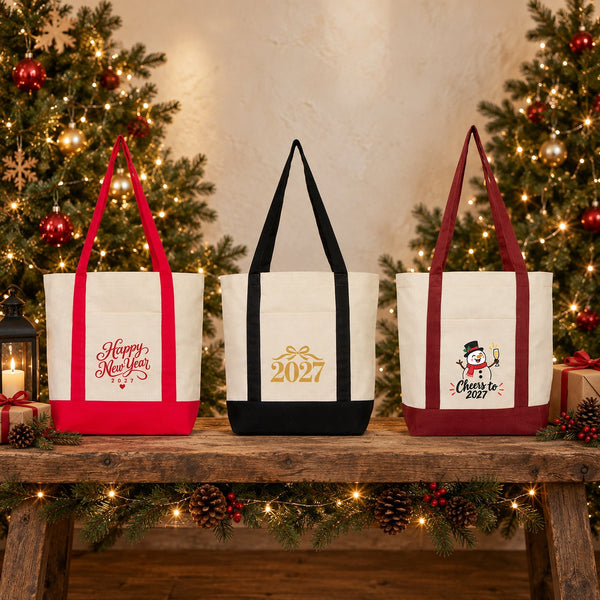Three New Year 2027 canvas tote bags with red, black and burgundy straps standing side by side on a rustic wooden bench in front of Christmas trees, with Happy New Year, gold 2027 and snowman prints