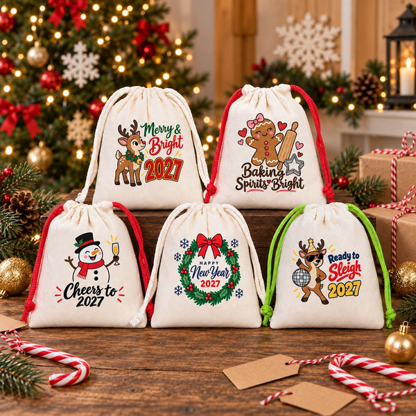Five cotton drawstring pouches with red, green and natural cords and different Christmas and New Year 2027 designs arranged as bulk favours and gifts for a class, a team or guests