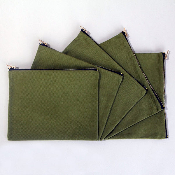 Real photo of five olive green cotton clutch bags fanned out, showing the flat pouch and brass zippers