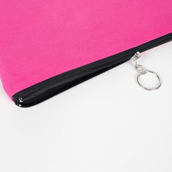 Close-up of a pink pouch with a black zipper and keychain on a white background