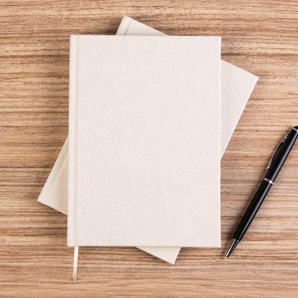 Blank natural canvas notebook with pen on a wood desk – A5, 7.9 x 5.5 in (20 x 14 cm), unprinted cotton cover | Pamusan.com