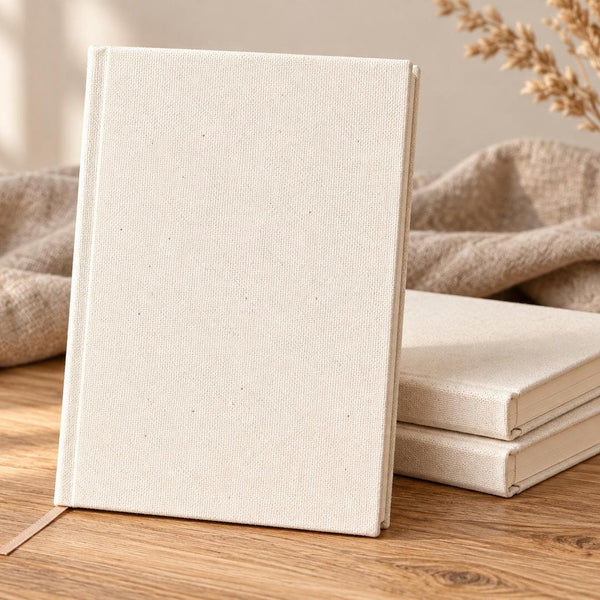 Natural canvas notebook standing upright with a stack of blank notebooks and linen cloth | Pamusan.com