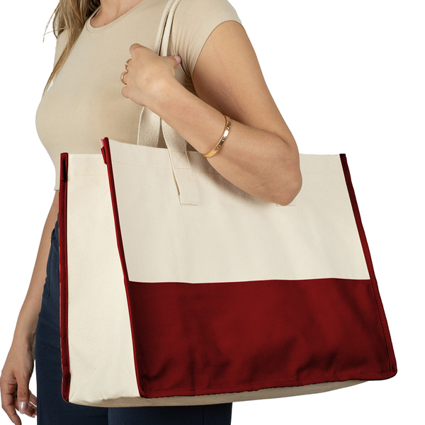 Woman carrying large canvas tote bag with burgundy base – made from thick cotton canvas, ideal for everyday, market, or beach use