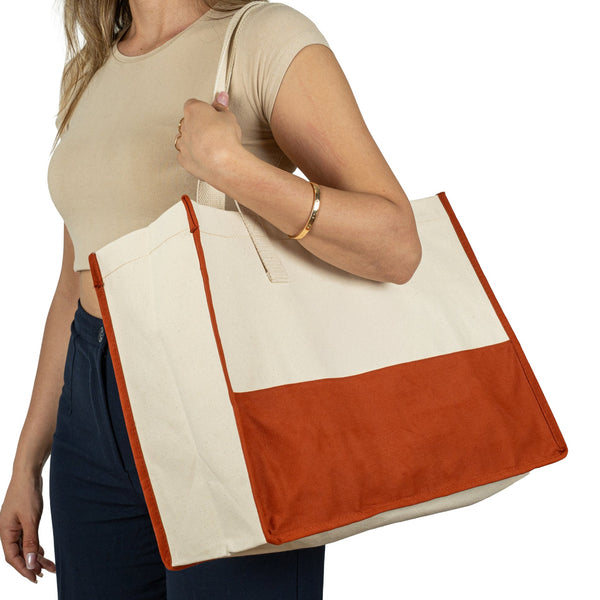 Woman holding large red and beige canvas tote bag – eco-friendly cotton shopping bag for everyday use
