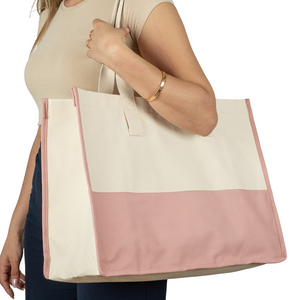Woman holding oversized cotton canvas tote with pink bottom – stylish and reusable bag for women
