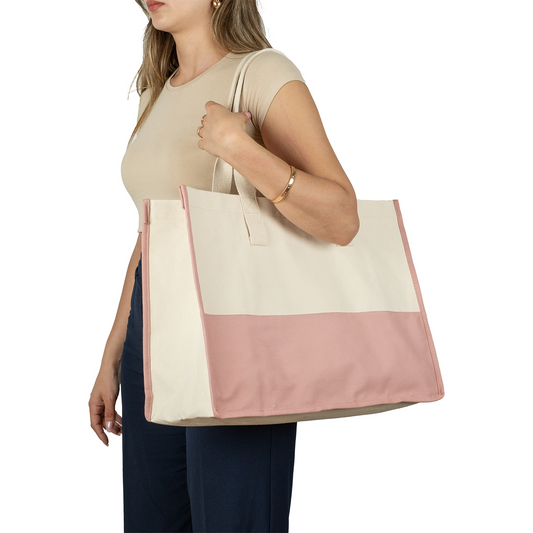 Woman holding oversized cotton canvas tote with pink bottom – stylish and reusable bag for women