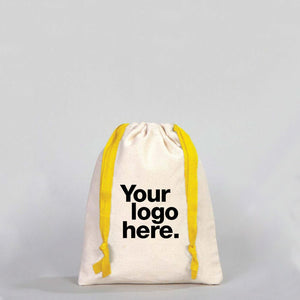 Canvas drawstring bag with yellow drawstrings and customizable text area on a gray background