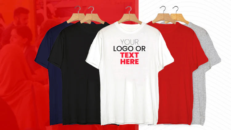 Four t-shirts in blue, black, white, and red on hangers with customizable text or logo area.