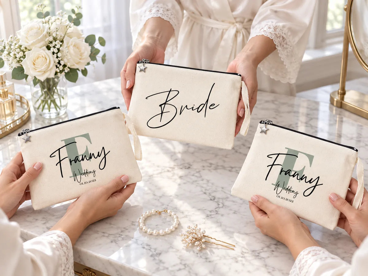 Bridesmaids in silk robes exchanging matching monogrammed cotton clutches over a marble vanity